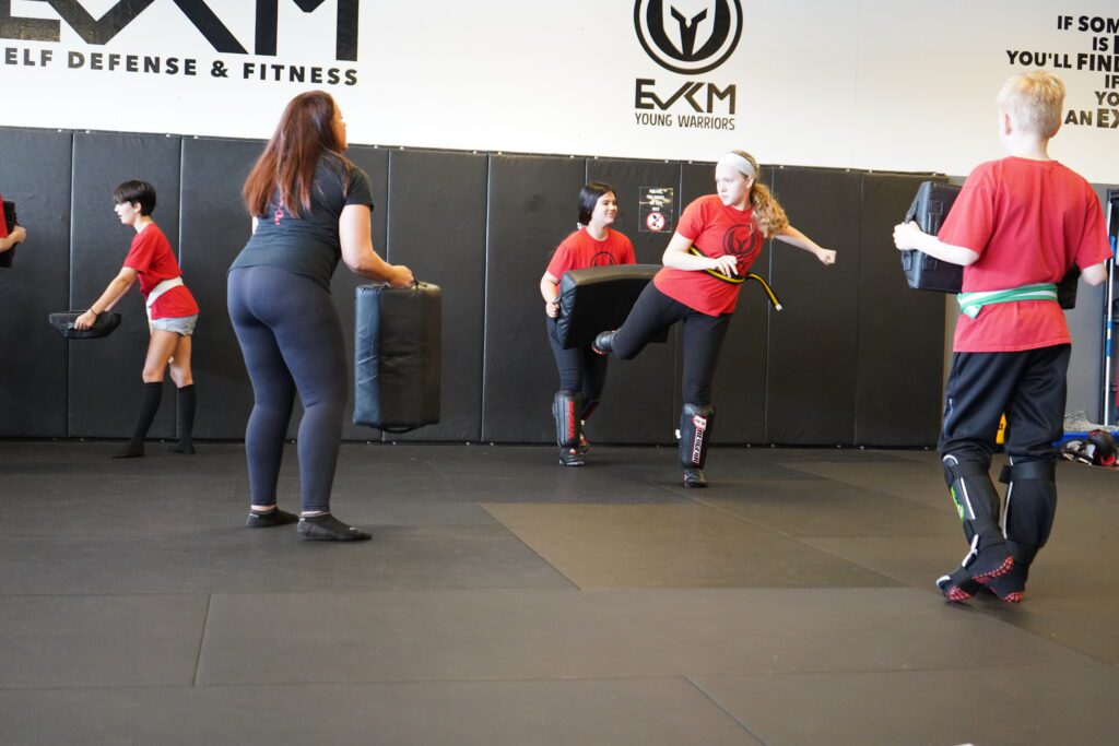 Young student practicing kick defense drill during EVKM kids training in Tempe Arizona