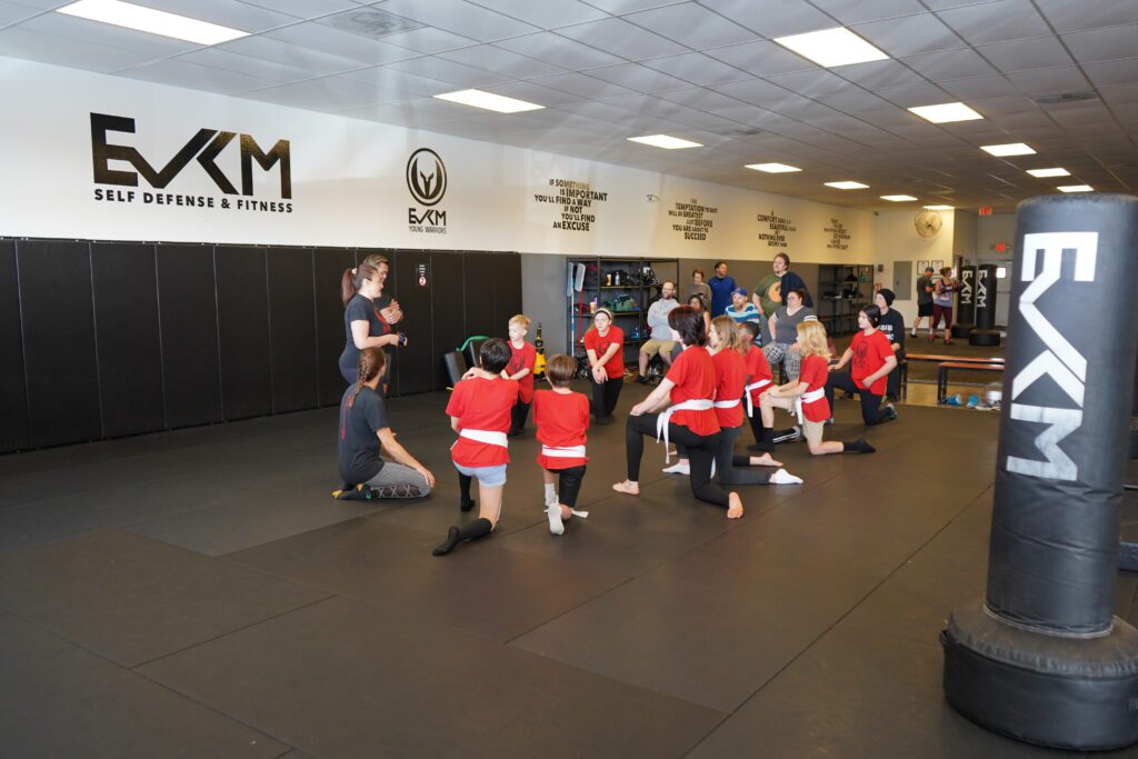 Kids listening to instructors during youth self defense class at EVKM in Tempe